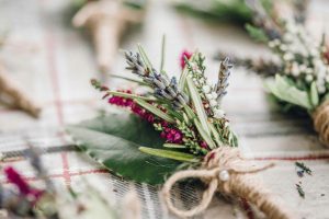 a close up grainy image of a natural buttonhole of herbs and heather.