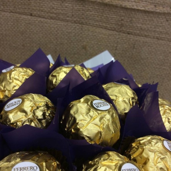 a posy style chocolate bouquet of ferrero rocher chocolates wrapped in dockers colours purple and white.