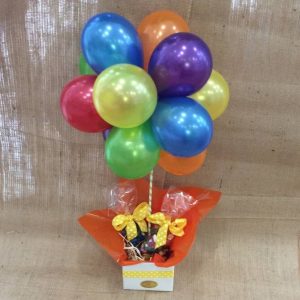 6 brightly coloured latex balloons made into a topiary. with two clear bags of jellybeans