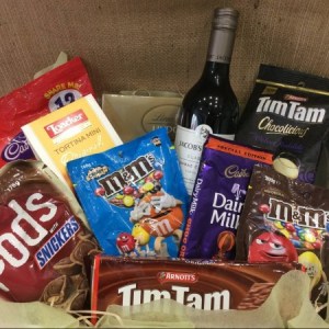 a hamper filled with chocolate products with a bottle of red wine