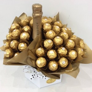 a chocolate bouquet of 40 ferrero rocher chocolates wrapped in gold, surrounding a bottle of sparkling wine.
