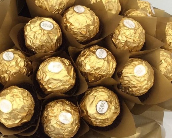 a chocolate bouquet made using 40 ferrero rocher chocolates wrapped in gold cellophane and a bottle of sparkling wine.