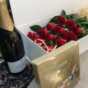 a presentation box of 12 long-stem red roses with a 750ml bottle of Australian sparkling wine and a box of Lindt chocolates.