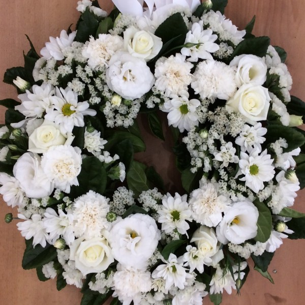 a small fresh flower wreath made using white flowers and green leaves
