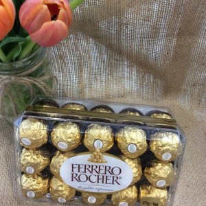 A box of Ferrero Rocher chocolates on a hessian background with a jar of tulips showing.