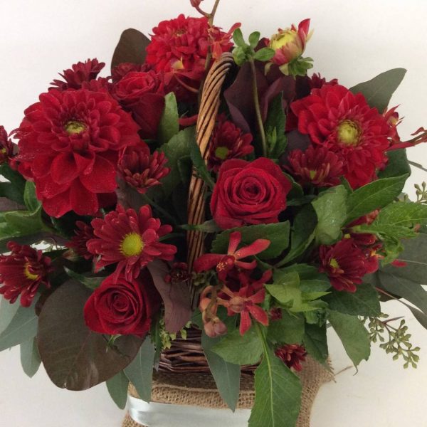 a wicker basket filled with red flowers.