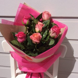 a hand tied bouquet of 6 pink roses, wrapped in neutral and pink paper and hessian.- A Touch of Class Florist