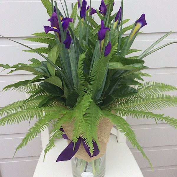 A glass cylinder vase arrangement of iris- A touch of Class Florist