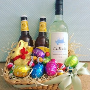 Easter Celebration Hamper contains a selection of easter eggs, a bottle of wine, and two WA beers in a seagrass basket - A Touch of Class Florist