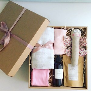 Baby Box in Pinks contains a number of baby items including clothing, a wrap, a rattle and some bath products gift wrapped in a craft box - A Touch of Class Florist Perth